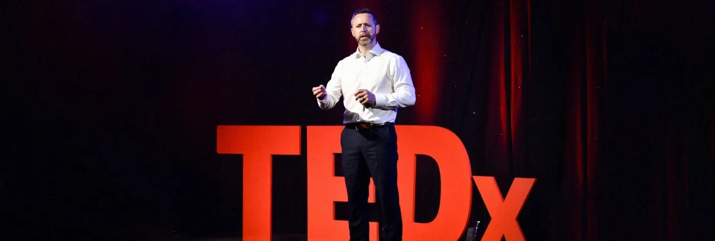 Kevin O'Reilly speaking on a TEDx stage